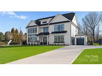 Stunning two-story home featuring a modern farmhouse design with black window frames and a well-manicured lawn at 1015 Kendall Dr # 4, Wesley Chapel, NC 28173