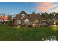 Charming brick home with a cozy front porch and manicured lawn at dusk at 158 White Rd, Wadesboro, NC 28170