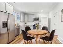 Bright eat-in kitchen featuring stainless steel appliances, gray cabinets, and a round dining table at 309 S Ransom St, Gastonia, NC 28052