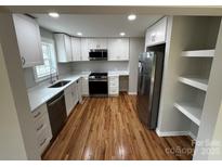 Bright kitchen features white cabinets, quartz countertops, stainless steel appliances, and hardwood floors at 112 Mccray Ave, Kannapolis, NC 28081