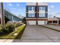 Modern townhome featuring a two-car garage and stylish blue and white exterior at 327 Coxe Ave, Charlotte, NC 28208