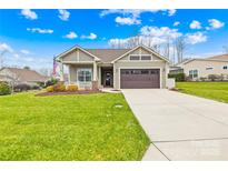 Curb appeal abounds in this charming ranch home boasting a 2-car garage and manicured lawn at 423 Granite Lake Ct, Denver, NC 28037