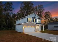 Two-story house with gray siding, brick accents, and a two-car garage at 7420 Gwynne Cir, Charlotte, NC 28214