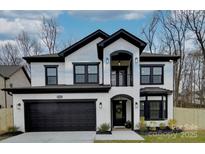 Beautiful two-story home with a black-and-white painted brick exterior, dark trim, and a two-car garage at 1308 Pleasant Plains Rd, Matthews, NC 28105