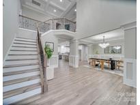 Bright foyer featuring a staircase with decorative iron railing, high ceilings, and an open floor plan at 1312 Pleasant Plains Rd, Matthews, NC 28105