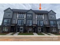 Modern townhome complex featuring gray siding, black brick accents, and large windows, showcasing contemporary design at 1312 Walter Taylor Way # Eqx0104, Charlotte, NC 28206