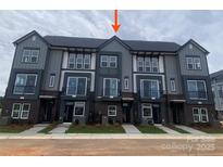 Modern townhome showcases gray siding, black brick accents, and a well-maintained lawn at 1316 Walter Taylor Way # Eqx0103, Charlotte, NC 28206
