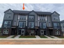 Modern townhome exterior features gray siding, brick accents, and a well-manicured lawn at 1320 Walter Taylor Way # Eqx0102, Charlotte, NC 28206