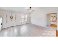 Bright living room featuring tile floors, ceiling fan, and natural light from the window at 150 Windmill Ct, Harmony, NC 28634