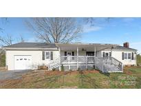 Newly renovated ranch home featuring a covered porch and detached garage at 12491 Oak Grove Rd, Stanfield, NC 28163