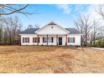 Charming exterior of a white, single-story home with a black roof and wooden columns accenting the front porch at 1306 Eddie St, Gastonia, NC 28054