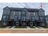 Modern townhome exterior featuring a sleek gray facade, large windows, and brick accents at 1308 Walter Taylor Way # Eqx0105, Charlotte, NC 28206