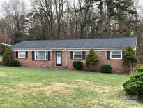 Brick ranch house with a landscaped lawn and driveway at 9608 Sunway Dr # 4, Mint Hill, NC 28227