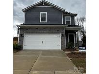 Two-story home with gray siding, stone accents, a two-car garage, and a well-maintained front yard at 102 Alden Ct, Shelby, NC 28152