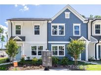 Charming townhome showcases a blue and white exterior with well-maintained landscaping at 3035 Howell Mill Rd # 51, Charlotte, NC 28208