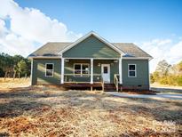 Charming single-story home with a covered front porch, featuring white columns and green siding at 528 Waco Rd, Kings Mountain, NC 28086