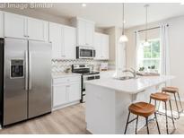 Modern kitchen with white cabinets, stainless steel appliances, and an island at 1805 Woodlands Pointe Dr, Charlotte, NC 28216