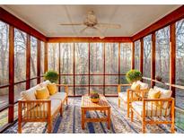 Bright sunroom with wooden furniture and view of the wooded backyard at 3915 11Th Ne St, Hickory, NC 28601