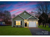 Charming one-story house with a green exterior, white garage door, and well-manicured lawn at 5513 Skycrest Dr, Charlotte, NC 28269