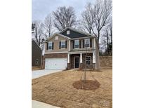 Charming two-story home featuring stone accents, a two-car garage, and a well-maintained yard at 126 Rustling Waters Dr, Mooresville, NC 28117