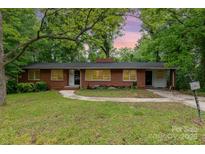 Charming single-story brick home featuring a spacious front yard and mature trees offering ample shade at 203 Azalea Rd, Lancaster, SC 29720