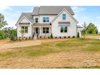 Stunning two-story home with board and batten siding and a well-manicured lawn at 320 Triple Ponds Ct, Clover, SC 29710