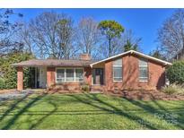 Brick ranch house with a landscaped lawn and driveway at 4017 Sulkirk Rd, Charlotte, NC 28210