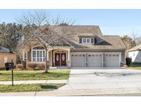 Two-story house with a three-car garage and manicured lawn at 500 Planters Way, Mount Holly, NC 28120