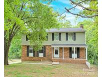 Charming two-story home featuring brick accents, black shutters, and a welcoming front porch at 9106 Nash Ave, Charlotte, NC 28213