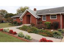 Brick ranch home with landscaped gardens and walkway at 129 Ann St, Salisbury, NC 28146