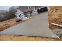 Long concrete driveway leading up to a partially-constructed home at 184 Maplewood Ln, Taylorsville, NC 28681
