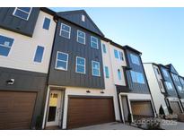 Modern 3-story townhome with dark gray and white exterior, 2-car garage, and landscaping at 7932 Cedarsmith Ct, Charlotte, NC 28217