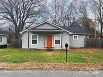 Charming gray house with orange door, a well-manicured lawn, and mature trees at 1206 N Boyce St, Gastonia, NC 28052