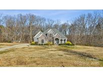 Charming home featuring a stone and gray brick exterior with a well-manicured lawn and mature trees at 4006 Sincerity Rd, Monroe, NC 28110