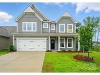 Charming two-story home with gray siding, a two-car garage, and a well-manicured lawn at 5404 Verona Rd # 36, Charlotte, NC 28213
