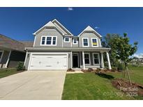 Charming two-story home with gray siding, white trim, two-car garage and manicured lawn at 5404 Verona Rd # 36, Charlotte, NC 28213