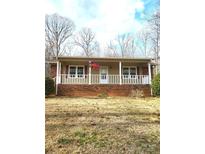 Charming single-story home with brick foundation and a cozy front porch with white railings at 1857 Williams Cir, Lancaster, SC 29720