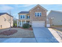 Two-story house with brick and siding, attached garage, and manicured lawn at 442 Hunton Forest Nw Dr, Concord, NC 28027