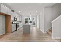 Beautiful, modern kitchen with gray cabinets, island, stainless steel appliances, and eat in space at 1750 Blanche St, Charlotte, NC 28262