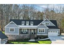 Charming gray two-story home with a well-manicured lawn and a two-car garage at 324 Patternote Rd, Mooresville, NC 28117