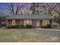 Brick ranch house with landscaped lawn and walkway at 4201 Westridge Dr, Charlotte, NC 28208