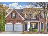 Brick front two-story home with two-car garage and landscaping at 8120 Oratorio Pl, Charlotte, NC 28270