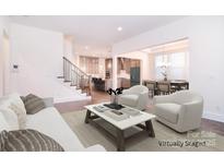 Spacious living room with hardwood floors, neutral tones, staircase, and seamless transition to kitchen and dining areas at 1364 Cedardale Ln, Denver, NC 28037