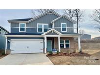 Two-story home with gray siding, brick accents, and a two-car garage at 115 Obadiah Ct, Troutman, NC 28115