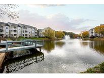 Beautiful view of apartments surrounding a pond with a fountain and wooden deck at 18742 Nautical Dr # 305, Cornelius, NC 28031