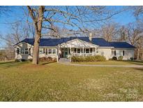 Ranch home with a metal roof, large yard, and covered porch at 222 Ingram Rd, Statesville, NC 28625