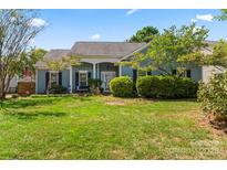 Charming single-story home with well-manicured lawn, complemented by beautiful landscaping and a welcoming entrance at 8523 Albury Walk Ln, Charlotte, NC 28277