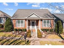 Charming brick home with manicured landscaping, gray shutters, and a welcoming front porch at 18119 Coulter Pkwy, Cornelius, NC 28031