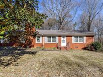 Charming brick home featuring a well-manicured front yard and classic white trim around the windows at 1830 Light Brigade Dr, Matthews, NC 28105