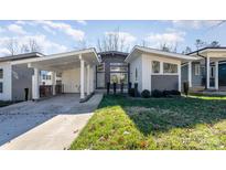 Modern home with gray and white exterior, carport, and landscaped lawn at 1906 Lakedell Dr, Charlotte, NC 28215